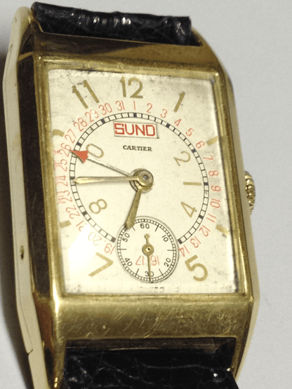 Rare 1960 Cartier Tank Day Date in yellow gold, featuring a multi-layered dial with Arabic numerals, day and date display, and a manual-winding movement.