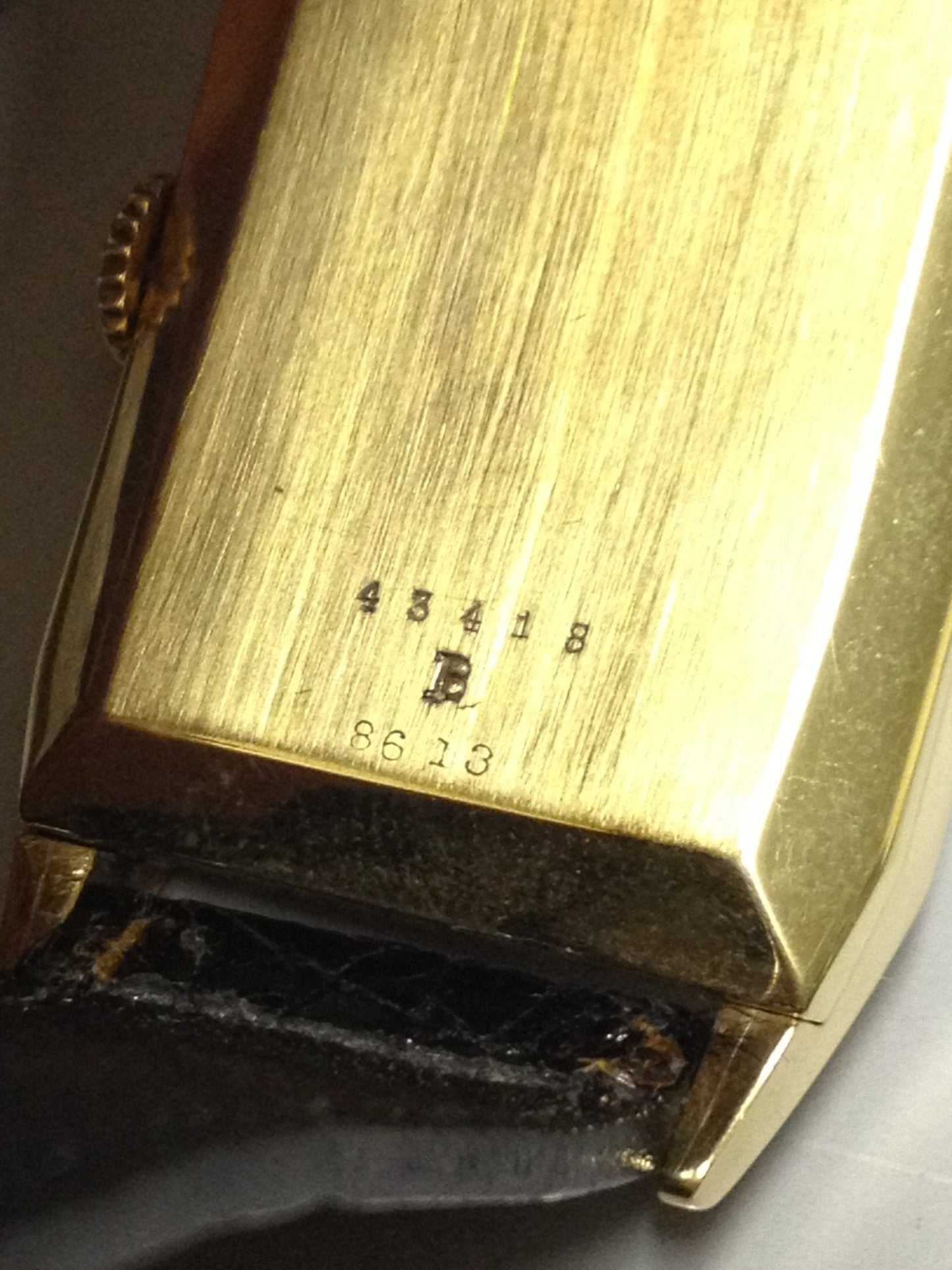 Rare 1960 Cartier Tank Day Date in yellow gold, featuring a multi-layered dial with Arabic numerals, day and date display, and a manual-winding movement.