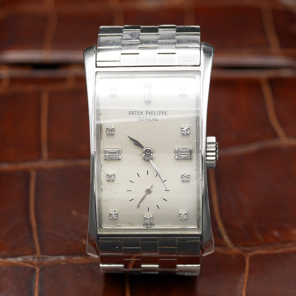 Patek Philippe Hour Glass Ref 1593 in Platinum, 1956. Oversized rectangular case, silver dial, diamond indexes. Iconic mid-century design, highly collectible.