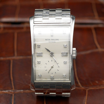 Patek Philippe Hour Glass Ref 1593 in Platinum, 1956. Oversized rectangular case, silver dial, diamond indexes. Iconic mid-century design, highly collectible.
