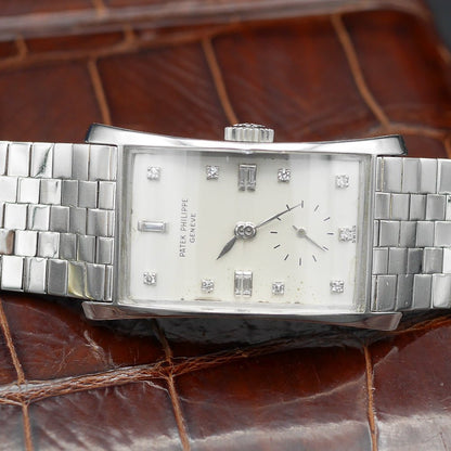 Patek Philippe Hour Glass Ref 1593 in Platinum, 1956. Oversized rectangular case, silver dial, diamond indexes. Iconic mid-century design, highly collectible.
