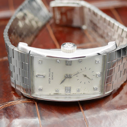 Patek Philippe Hour Glass Ref 1593 in Platinum, 1956. Oversized rectangular case, silver dial, diamond indexes. Iconic mid-century design, highly collectible.