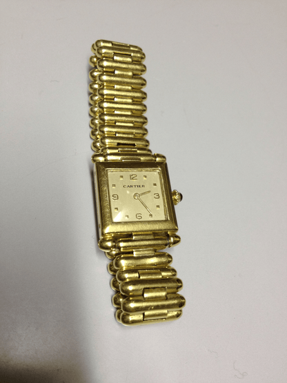 Vintage Cartier Square Watch in yellow gold, circa 1950, featuring a champagne dial, Arabic numerals, cabochon sapphire crown, and bullet-link bracelet.