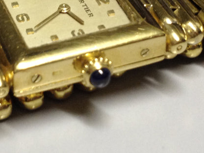 Vintage Cartier Square Watch in yellow gold, circa 1950, featuring a champagne dial, Arabic numerals, cabochon sapphire crown, and bullet-link bracelet.